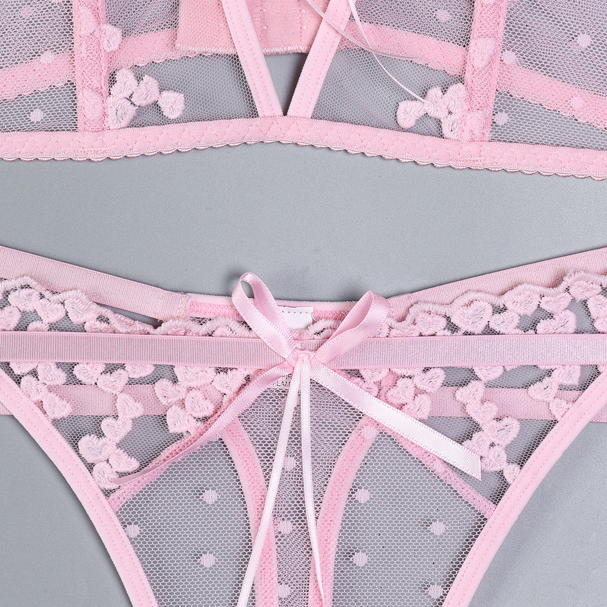 Floral accents on pink three-piece lingerie set