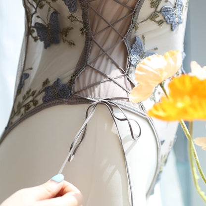 Close-up of the ribbon lingerie design featuring a lace-up detail on a sheer bodysuit with grey butterfly embroidery, showcasing adjustable ribbon straps for a customizable fit.