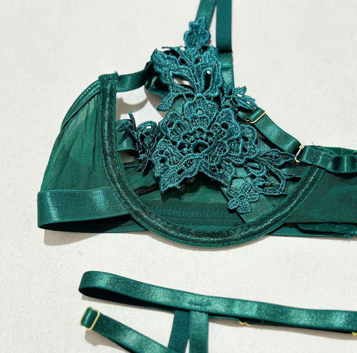 Green three-piece lingerie set with garter straps design