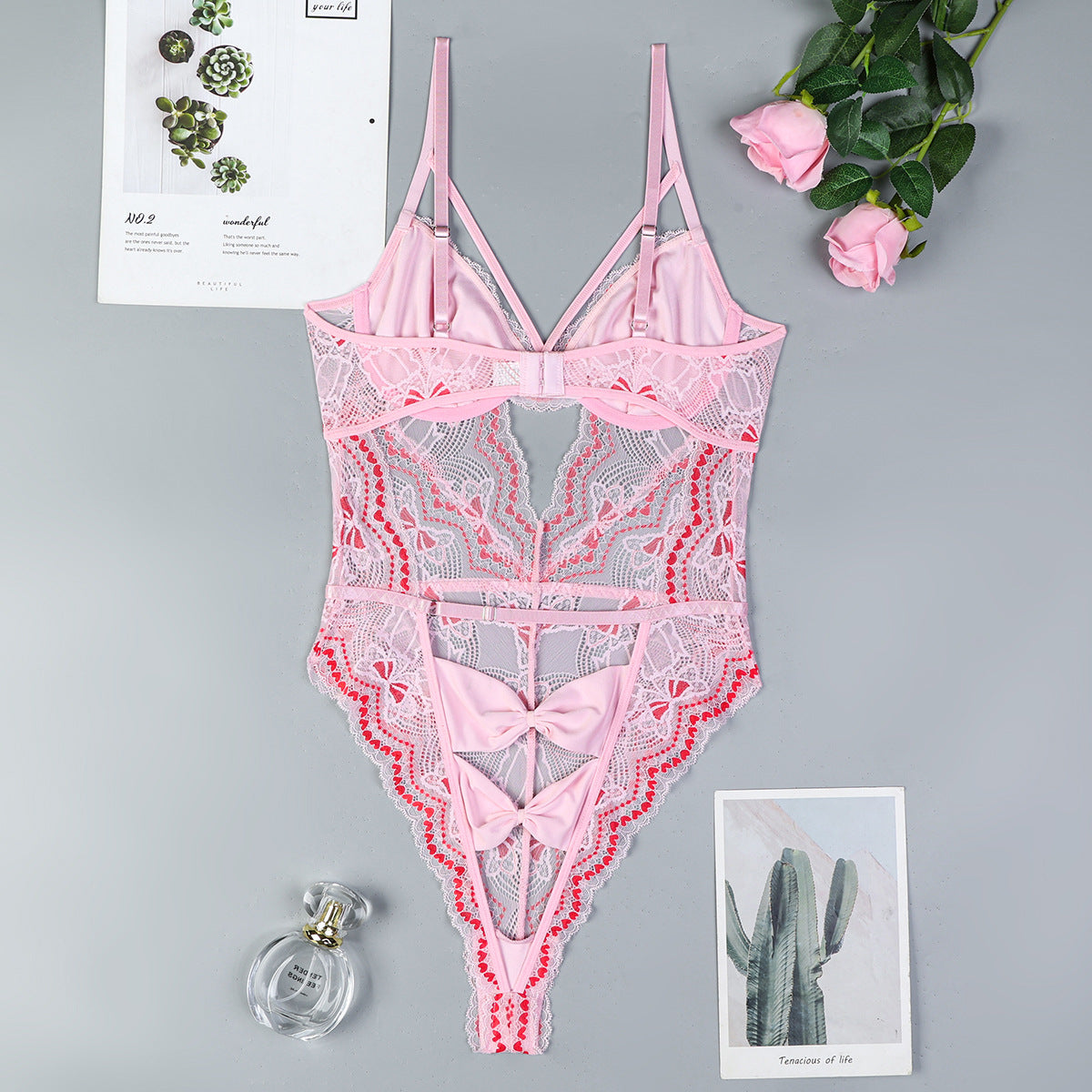 Bow accents on pink lingerie bodysuit