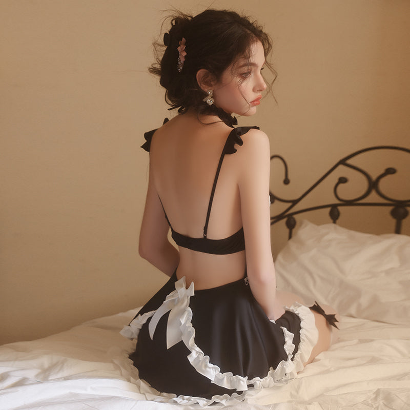Seated back view of black and white maid cosplay dress