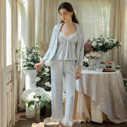 Model wearing the light blue floral pajama cardigan open over the lace cami and pants